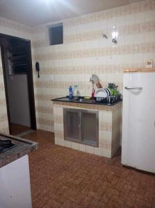 a kitchen with a sink and a refrigerator at Apartamento Saquarema Centro in Saquarema