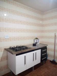 a kitchen with a stove and a counter top at Apartamento Saquarema Centro in Saquarema