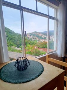 een kamer met een tafel en een groot raam bij É Hostel - Guesthouse in Ouro Preto