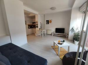 a living room with a couch and a table at City Center White Apartment! in Skopje