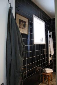 a bathroom with black tiled walls and a window at Villa Lillebo in Bengtsfors +17 photos