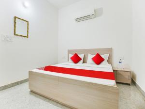 1 dormitorio con 1 cama grande con almohadas rojas en OYO Hotel Classic in, en Mohali