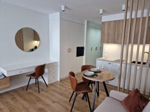 a living room with a table and chairs and a kitchen at Apartament Sunray in Krakow