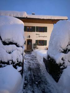 a house covered in snow with a fence at Haus Ferienglück in Reit im Winkl
