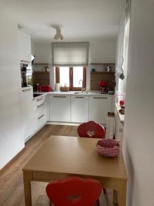 a kitchen with a wooden table and two red chairs at Haus Ferienglück in Reit im Winkl