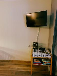 a room with a table with a tv on the wall at Family Apartment MiniGlück in Sankt Englmar
