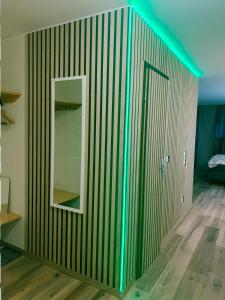 a room with a green stripped wall with a mirror at Family Apartment MiniGlück in Sankt Englmar