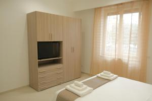 a bedroom with a television and a bed with towels at Carpe Diem Holiday House in Massa Lubrense +16 photos