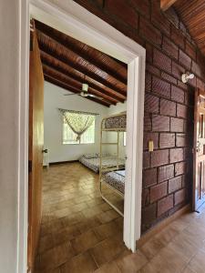 a room with two bunk beds and a brick wall at Finca la Querendona in Santa Fe de Antioquia