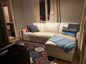 a living room with a white couch and blue pillows at Lillhuset in Järbo