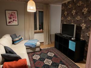 a living room with a white couch and a flat screen tv at Lillhuset in Järbo