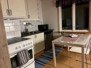 a kitchen with a white stove and a table at Lillhuset in Järbo