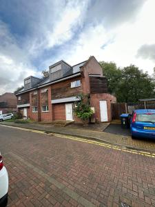 a brick house with a car parked in front of it at Wembley Accommodation in London