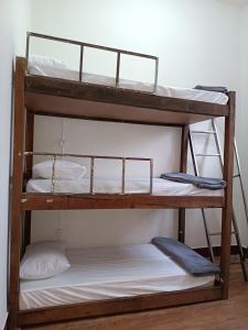 two bunk beds in a room with white sheets at É Hostel - Guesthouse in Ouro Preto