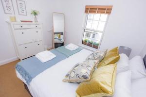a bedroom with a large white bed and a window at Midsummer Cottage Cambridge in Chesterton +1 photo