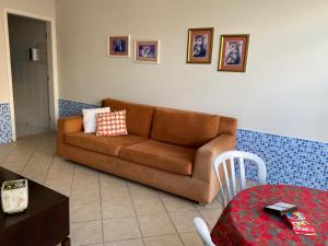 a living room with a brown couch and a table at Casa do Jardim in Curitiba