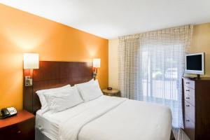 a hotel room with a bed and a television at Avia Residences on Research - Extended Stay in Westborough