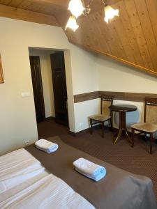 a room with a bed and a table and chairs at Willa Bella in Zakopane