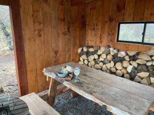 una cabaña de madera con una mesa y un montón de troncos en Tiny Harry Malalcahuello, en Curacautín