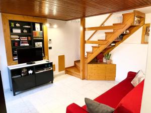 sala de estar con sofá rojo y escalera en Ca al Borgo - Lago di Como, en Faggeto Lario 