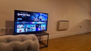 a flat screen tv sitting in a room with a couch at Homestay by BIC Melbourne 14 - LEEDS in Morley