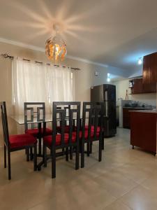 a dining room with a table and chairs and a kitchen at Stylish Stay Ciudad Juan Bosch in Los Paredones