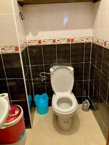 een badkamer met een toilet en zwart betegelde muren bij Appartement beau et familial connecté in Tanger