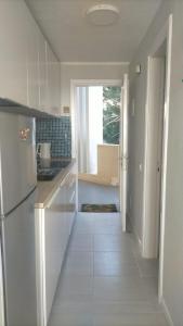 cocina blanca con nevera y pasillo en Apartment Casa M in Morro Jable, en Morro del Jable