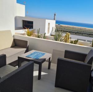 a balcony with chairs and tables and a view of the ocean at Apartment Casa M in Morro Jable in Morro del Jable