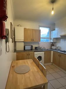 a kitchen with a wooden table and a stove and a sink at Beautiful Studio Apartment No4 Forest Road in London