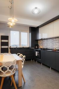 a kitchen with a table and chairs in a kitchen at Duplex lux - Thoria in Bucharest