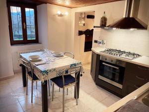 cocina con mesa y fogones horno superior en Ca al Borgo - Lago di Como, en Faggeto Lario 