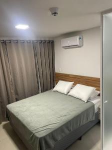 a bedroom with a bed with two pillows at Flat João Pessoa Frente Mar - Banheira - Jacuzzi Privativa in João Pessoa +29 photos