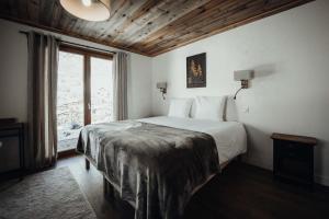 ein Schlafzimmer mit einem Bett und einem großen Fenster in der Unterkunft Nards furnished chalet in Praz-sur-Arly
