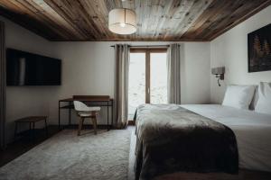 a bedroom with a bed and a desk and a window at Nards furnished chalet in Praz-sur-Arly