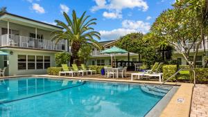 a swimming pool with patio furniture and a house at Sun Dek Beach House in Boynton Beach