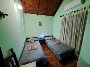 duas camas num quarto com paredes verdes em Lo de Mijo - Cerca de Parque Termal Dolores em Dolores