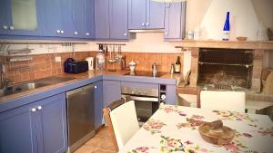 Una cocina con gabinetes azules y una mesa con sillas. en Rural Canary House by Deihu Experiences, en San Miguel de Abona