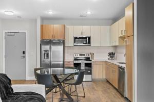 een keuken met een tafel en een roestvrijstalen koelkast bij The Platinum Suite Penthouse The Gulch in Nashville +20 foto's