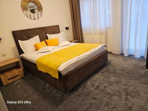 - une chambre dotée d'un grand lit avec des oreillers orange et blancs dans l'établissement Străjerii Cetății, à Tîrgu Neamţ