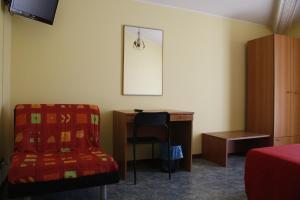 a room with a desk and a chair and a table at Hotel Narnia in Narni