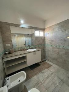 bagno con servizi igienici, lavandino e specchio di Complejo “Aloe Vera” a Villa Dolores