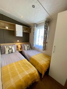 a bedroom with two beds and a window at Hot tub. Countryside. Coast. 5* Patrington Haven Leisure Park, East Yorkshire in Patrington