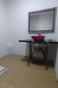 a bathroom with a red sink and a mirror at Casa Hebe in Villa Parque Siquiman