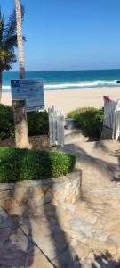 una playa con sillas y un cartel y el océano en Cimarron Suites Playa Parguito, en El Cardón