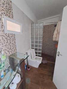 een badkamer met een toilet en een glazen douchecabine bij Happy House Madeira in Funchal