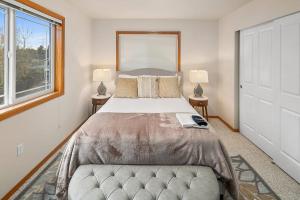 a bedroom with a large bed and two windows at Cozy Cloverdale BY Betterstay in Seattle