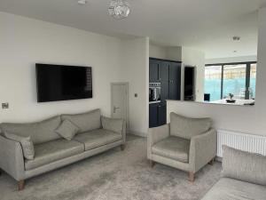 a living room with a couch and two chairs at Salt Life Portstewart in Portstewart