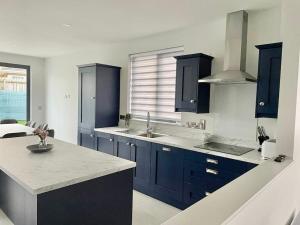 a kitchen with blue cabinets and a counter top at Salt Life Portstewart in Portstewart