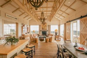 a large living room with a table and chairs at Rosewood Cape Kidnappers in Te Awanga